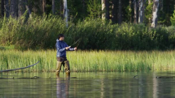 Młody człowiek fly-fishing w jeziorze — Wideo stockowe