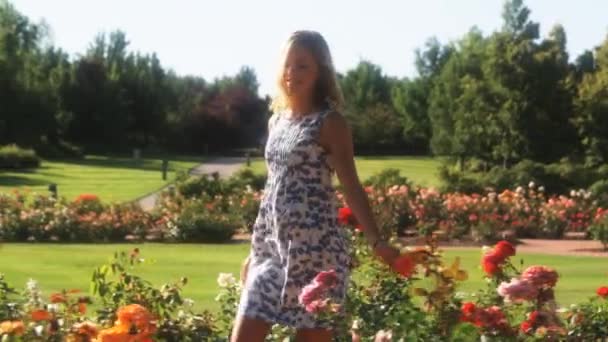 Kvinnan promenader genom sommarträdgård — Stockvideo