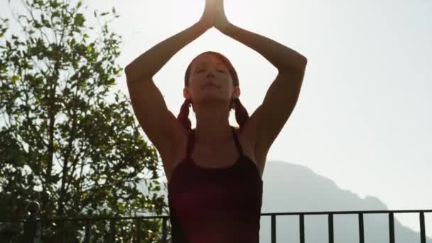 Vrouw doet yoga op balkon — Stockvideo