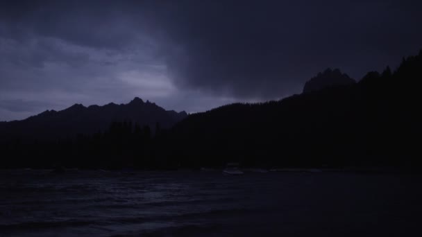 Nubes oscuras sobre siluetas de montaña y lago — Vídeos de Stock