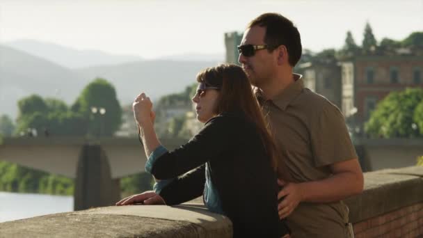Couple taking photographs standing by ledge — Stock Video
