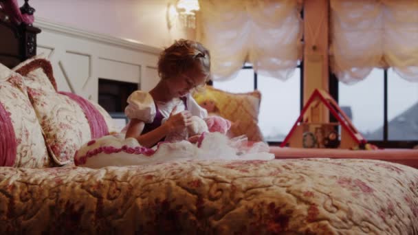 Menina brincando com animais de pelúcia na cama — Vídeo de Stock