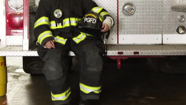 Tűzoltó ül vissza a tűzoltóautó — Stock videók