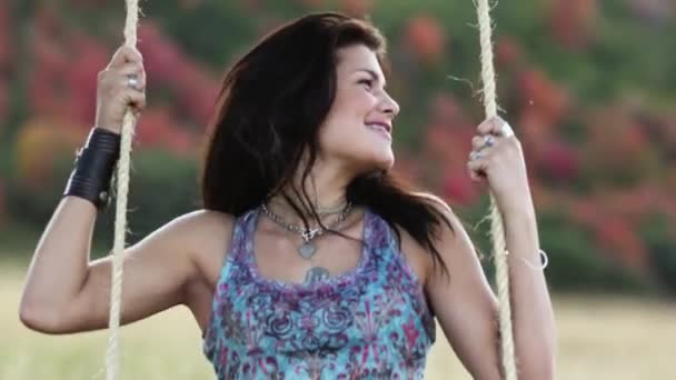 Tonårig flicka gungar på repet swing på fältet — Stockvideo