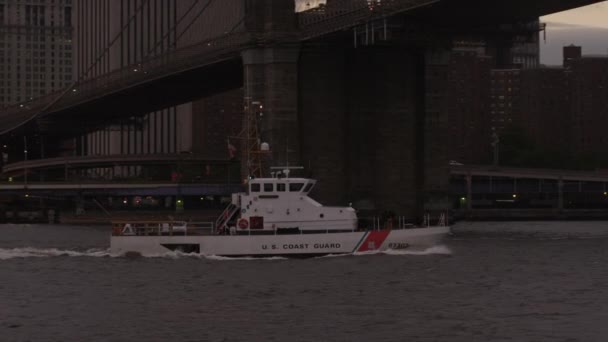 Barco patrulla pasando por debajo del puente Brooklyn — Vídeo de stock