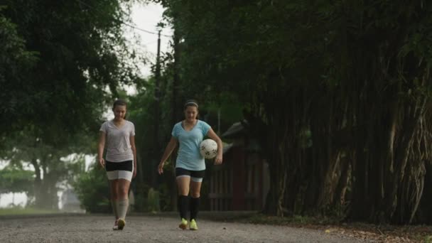 Joueurs de football marchant sur la route de terre — Video