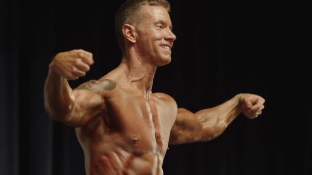 Bodybuilder posiert bei Wettkampf auf der Bühne — Stockvideo