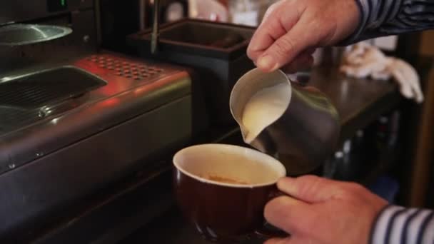 Människan häller mjölk i kaffe — Stockvideo