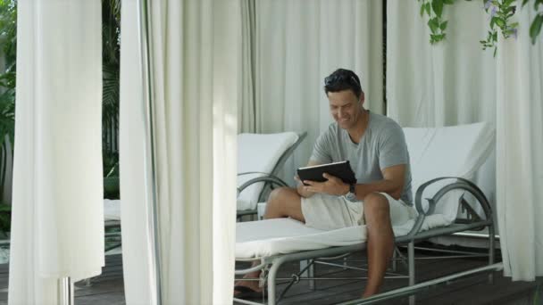 Man met digitale tablet in de patio — Stockvideo