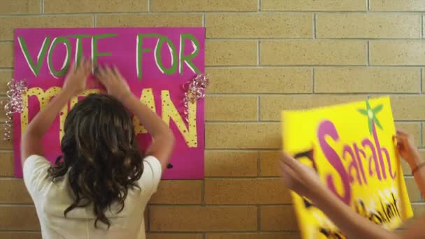 Studenten kleben Plakate an Wand — Stockvideo