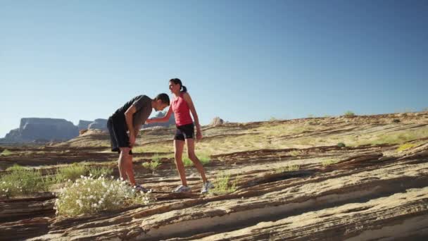 Pareja estirándose en el desierto — Vídeos de Stock