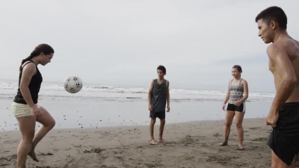 Les gens qui jouent avec le ballon de football sur la plage — Video