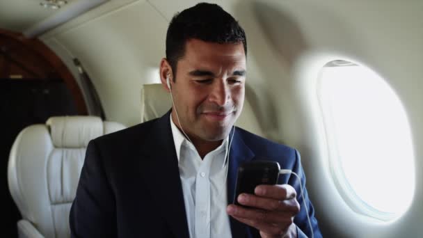 Бизнесмен слушает MP3Player в самолете — стоковое видео