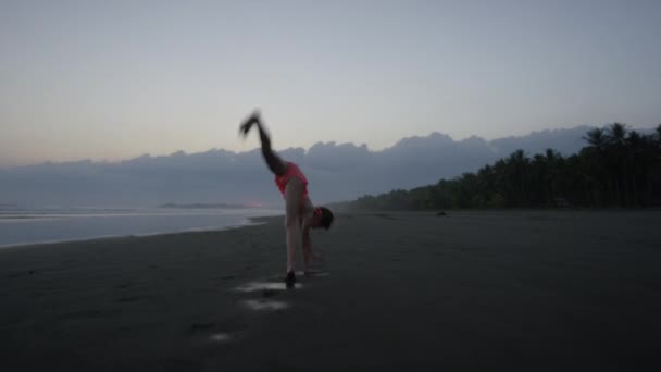 Lány csinál cigánykerék strandon — Stock videók