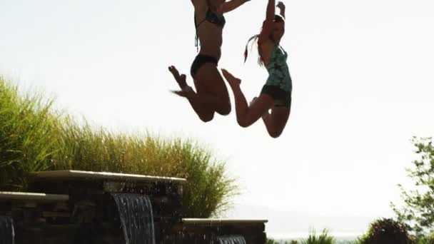 Dospívající dívky, skákat do bazénu — Stock video
