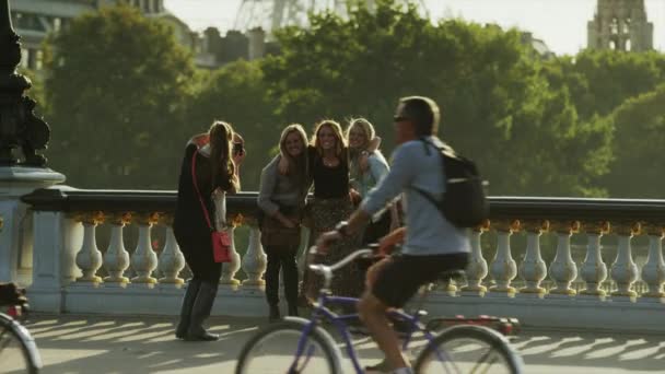 Женщина фотографирует друзей на мосту — стоковое видео