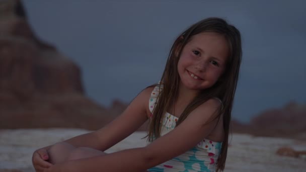 在夜晚的沙滩上的小女孩微笑着 — 图库视频影像