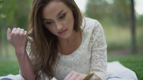 Mujer leyendo libro en hierba — Vídeos de Stock