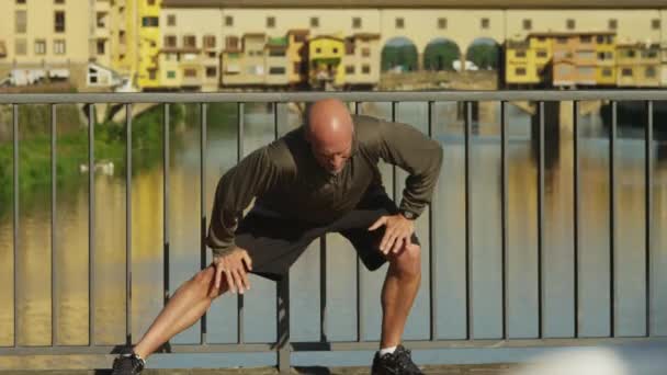 Muž táhnoucí se na mostě — Stock video