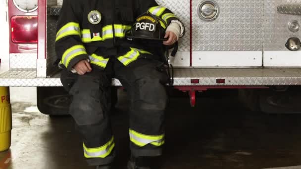 Female firefighter sitting at back of fire engine — Stock Video