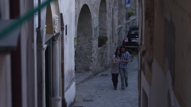 Paar lopen op smalle straat — Stockvideo