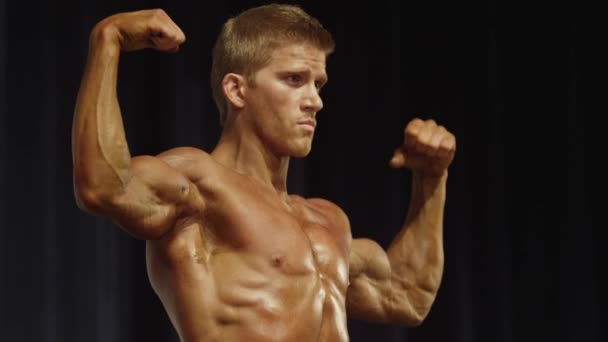 Bodybuilder posing on stage at competition — Stock Video