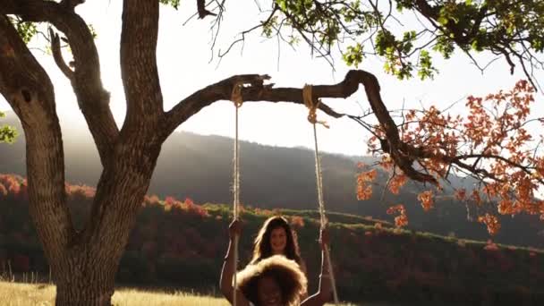 Zwei Teenager-Mädchen spielen auf der Seilschaukel — Stockvideo