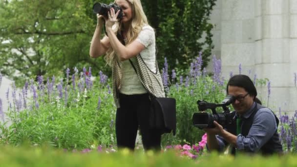 Чоловік з кінокамерою і жінка в саду — стокове відео