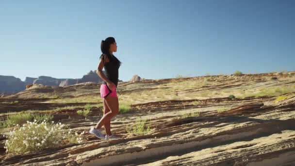 Жінка розтягується і бігає в пустелі — стокове відео