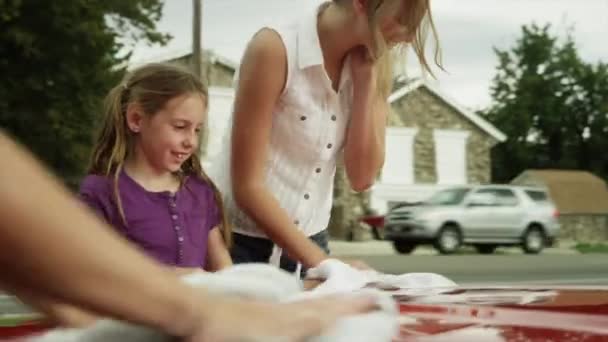 Speelse vrouwen drogen auto kap — Stockvideo