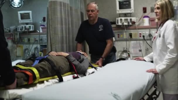 Sanitäter legen Patient auf Krankenhausbett — Stockvideo