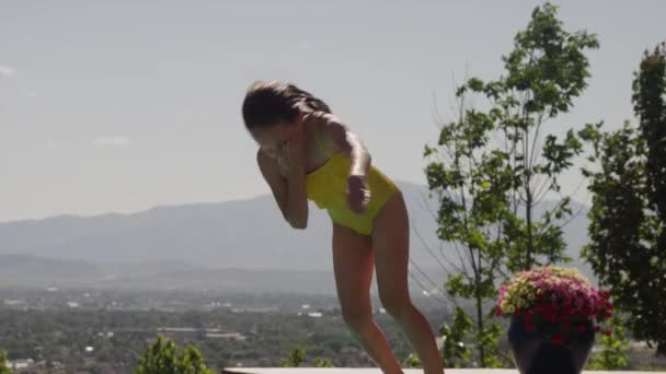 Girl somersaulting into swimming pool — Stock Video