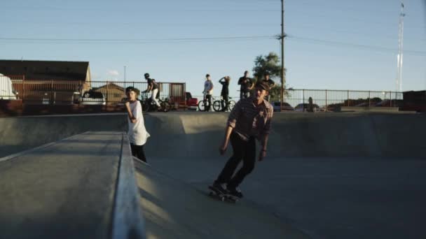 Skateboarders rampa deslizante en skatepark — Vídeo de stock