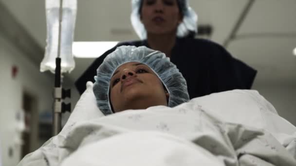 Enfermera empujando paciente femenino en camilla — Vídeos de Stock