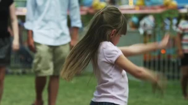 Девушка танцует в парке развлечений — стоковое видео