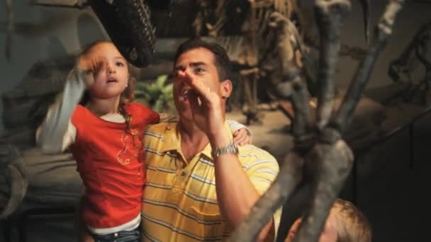 Семья смотрит на скелет динозавров — стоковое видео