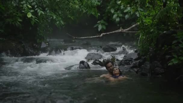 Пара отдыхает в текущей реке — стоковое видео