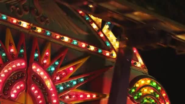 Pessoas em passeio de parque de diversões iluminado — Vídeo de Stock