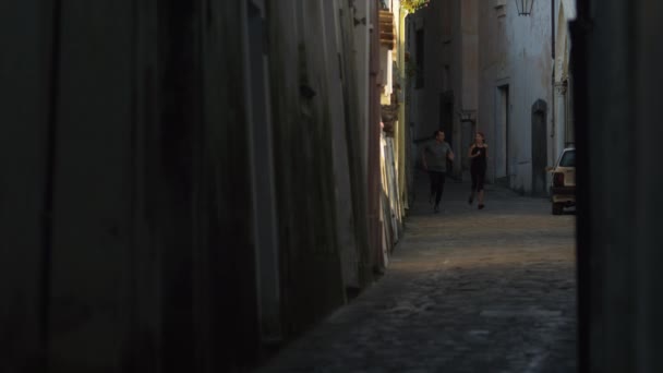 Paar joggt in enger Straße — Stockvideo