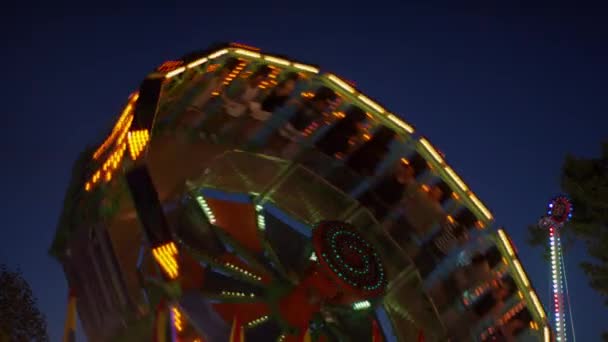 Светящиеся аттракционы в парке развлечений — стоковое видео