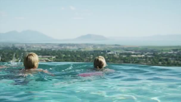 Vrienden zwemmen in het landschapszwembad — Stockvideo