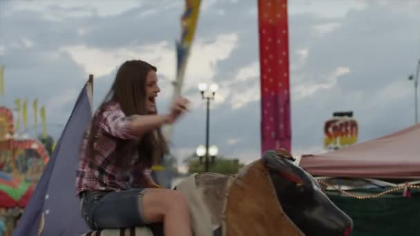 Дівчина їде на механічному бику — стокове відео