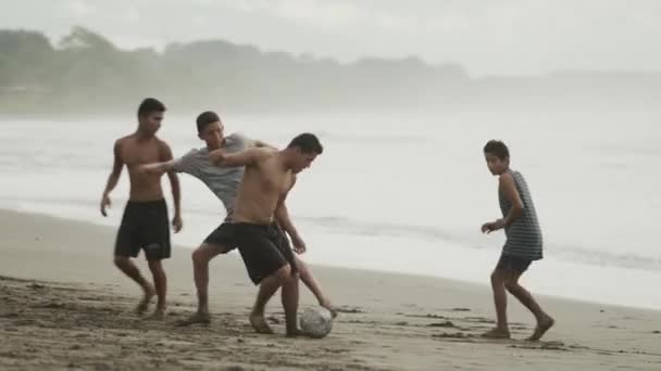 Personer som spelar fotboll på stranden — Stockvideo