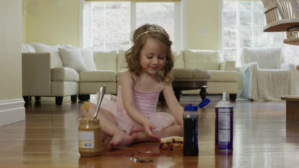 Девушка-балерина ест сэндвич на полу — стоковое видео