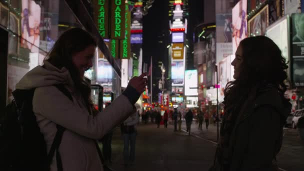 Vrouwen met behulp van cameratelefoon in Times Square — Stockvideo