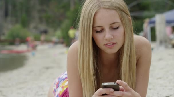 Mujer usando teléfono celular en la playa — Vídeo de stock