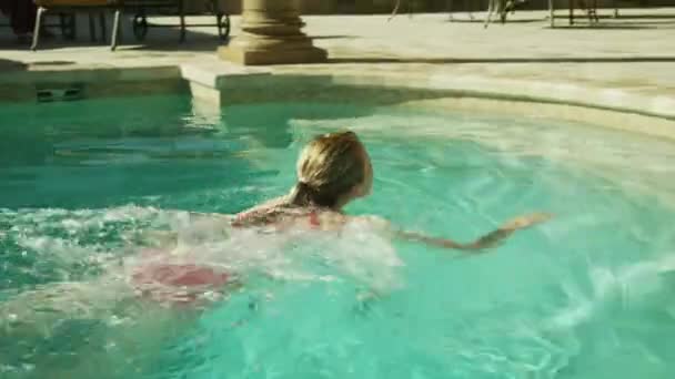 Trekken vriend van het meisje in zwembad — Stockvideo