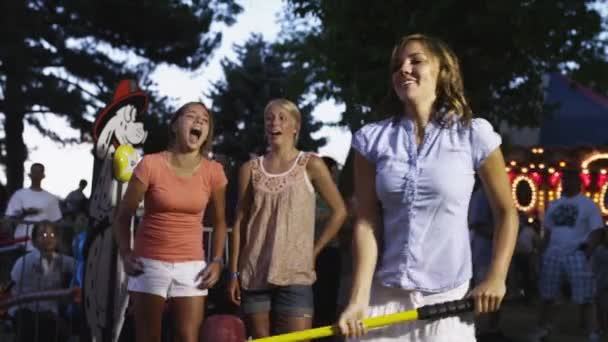 Girls using fairground strength tester — Stock Video