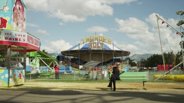 Man walking by amusement park ride — Stock Video