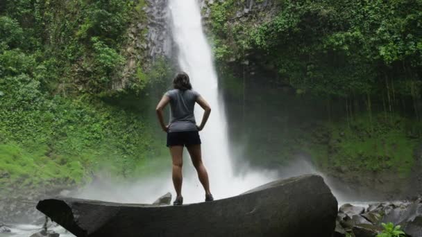 Hiker admiring waterfall in rain forest — Stock Video